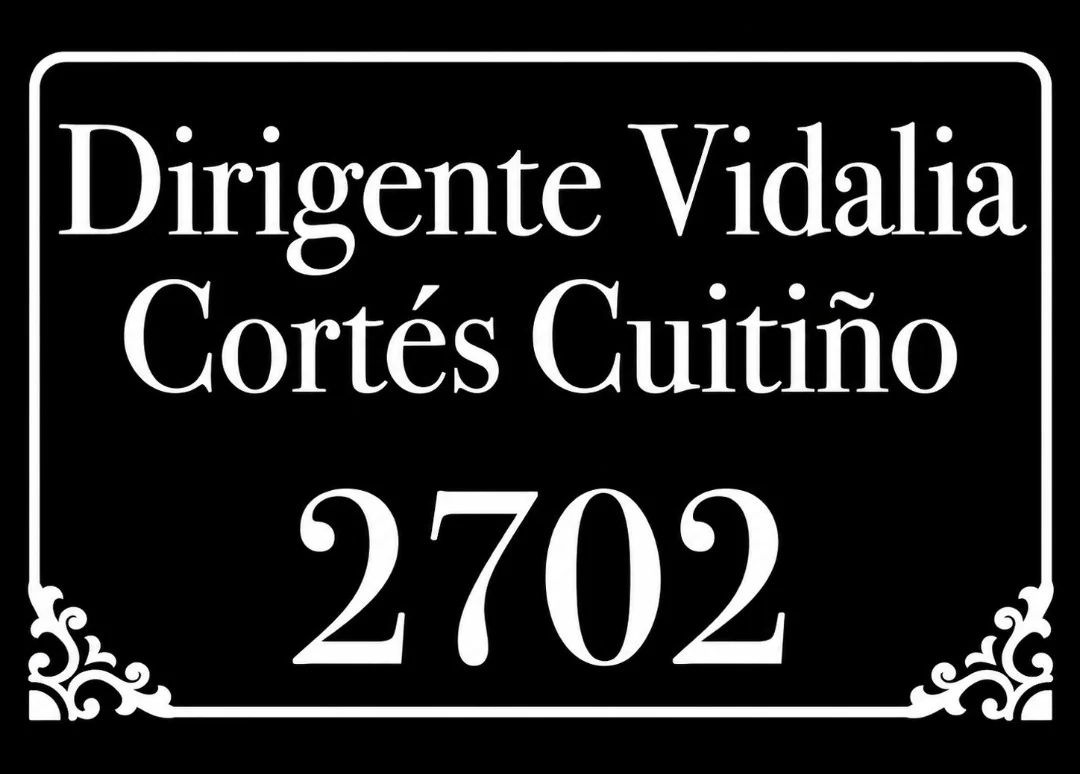 Diseño de Grafifoils: letrero negro con letras blancas y ornamentos en las esquinas, «Dirigente Vidalia Cortés Cuitiño 2702»