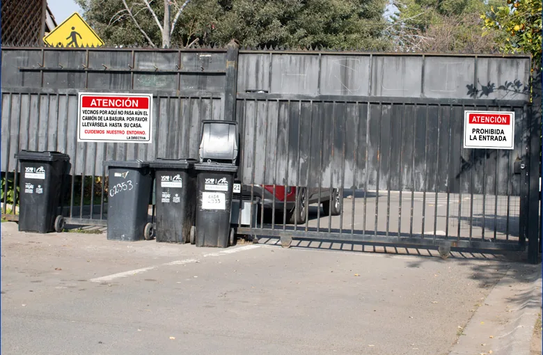 Portón con letreros de atención y prohibida la entrada